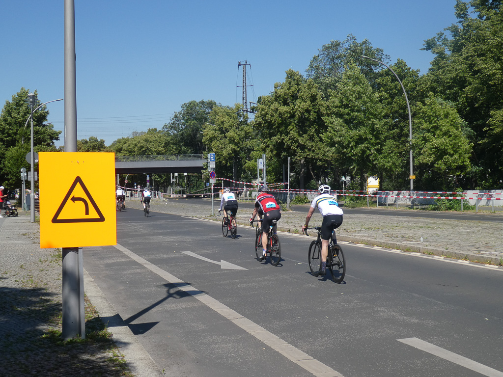 Gruppe Radfahrer passieren gelbes Verkehrsschild © SCC EVENTS / Petko Beier